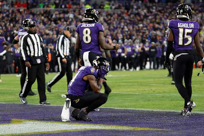 Zay Flowers crouches with his head in his hands in the endzone